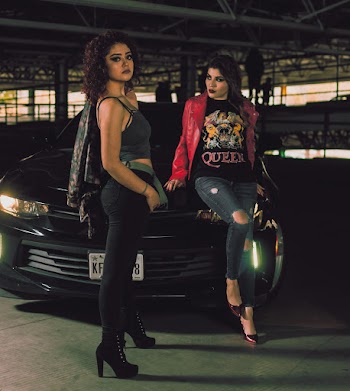 Two Woman Standing in Front of Vehicle in Building