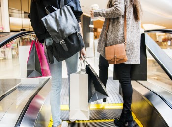 Two Woman Standing On Escalator