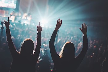 two woman standing on field of people