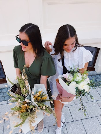 Two Woman Standing While Holding Flowers