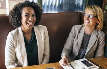Two Women Having a Conversation Laughing and Smiling