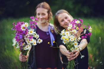 Two Women Holding Flowers 