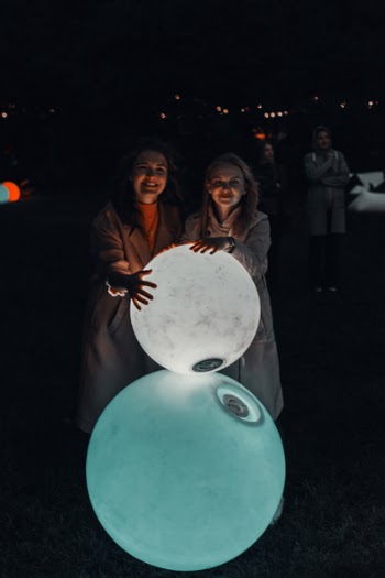 Two Women Holding Lighted Balls