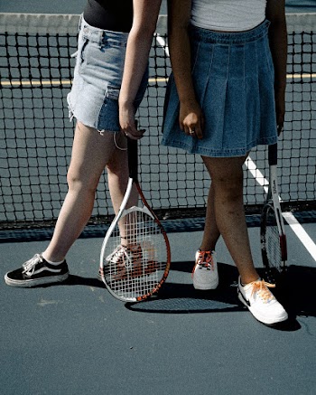 Two Women Holding Tennis Rackets