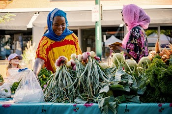 Two Women in Front of Vegetable Market