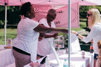 Two Women in White Shirts Beside Stall