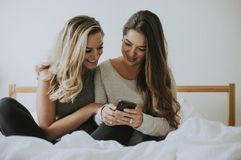 Two Women Looking at Black Smartphone