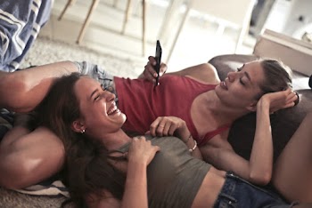Two Women Lying on Floor While Smiling