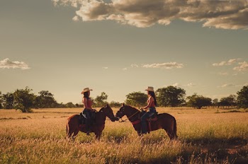 Two Women on Horses backs 