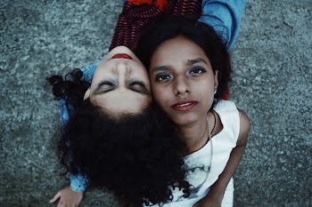 Two Women Sits on Gray Soil Taken