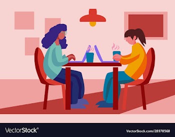 two women sitting at cafe and working