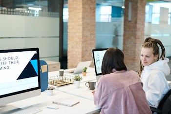 Two Women Sitting in Front of Computer