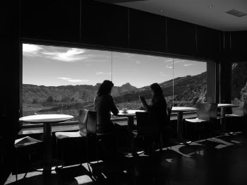 Two Women Sitting Near Glass Windows