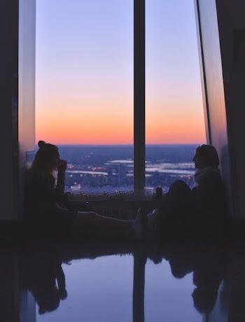 two women sitting near window