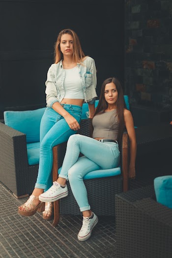 Two Women Sitting on Chair Next to Each Other