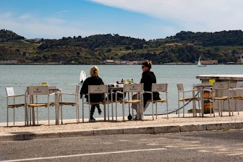 Two Women Sitting on Chairs Under Blue Sky