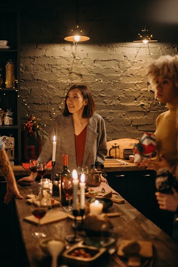 Two Women Standing Beside Table With Lighted Candles