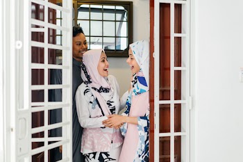 Two Women Standing By The Door