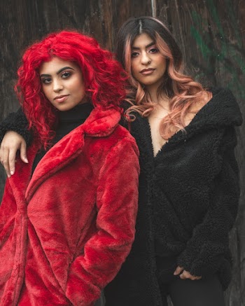 Two Women Standing Near Wall