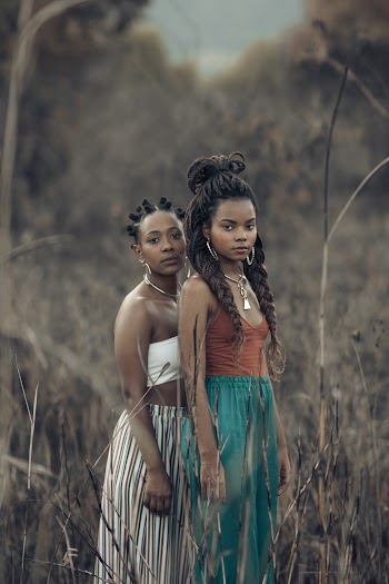 Two Women Standing on Grass Fiueld