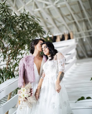 Two Women Standing on Stairway Near Plant