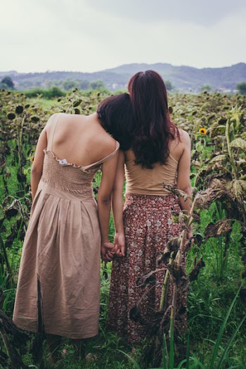 Two Women StandingIn Sunflower Field