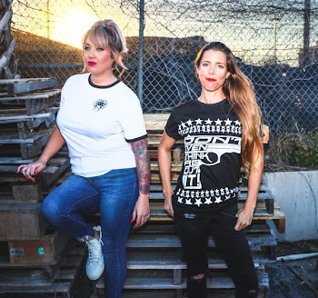 Two Women Taking Picture Near Pallets