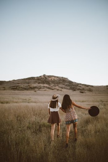 two women walking around near mountain at daytime
