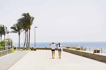 two women walking beside body of water