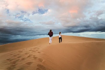 two women walking on desert