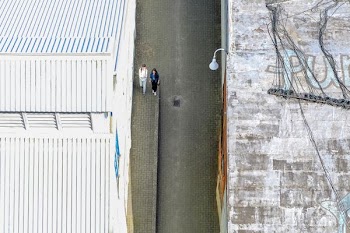 two women walking on road between houses