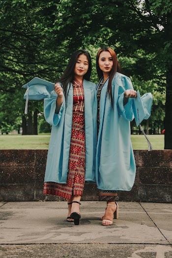 Two Women Wearing Blue Academic Suits Standing Near Trees
