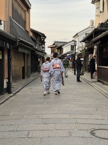 Two Women Wearing Blue Floral Hakamas Walking on Street