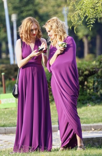Two Women Wearing Purple Dresses on Grass Field
