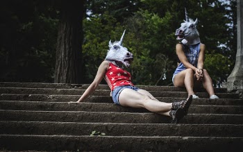 Two Women Wearing Unicorn Masks
