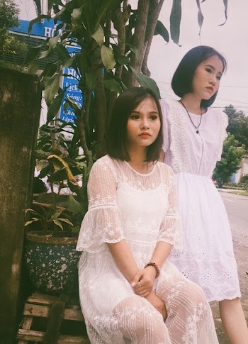 Two Women Wearing White Floral Dresses on Side Walk