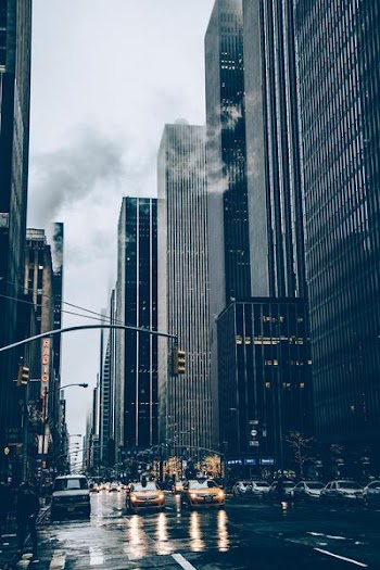 two yellow cars besides concrete buildings
