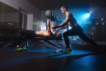 two young men twin brothers training with dumbbells, exercising workout in gym