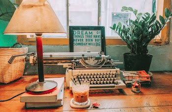 Typewriter Beside Table Lamp on Table