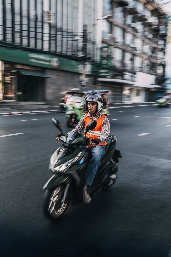 Typical motorbike taxi driver zooming through Bangkok city.