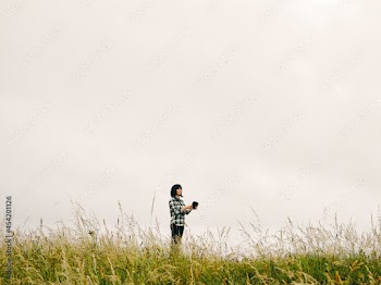 UK, Female hiker standing in grassy field