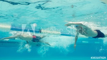 Underwater view athletic male swimmers competing in swimming pool