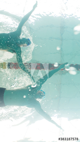 Underwater view male swimmers competing in swimming pool