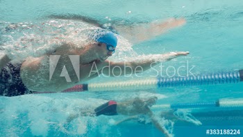 Underwater view male swimmers competing in swimming pool
