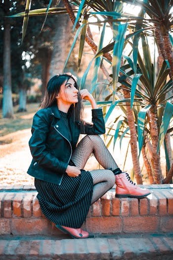 Unknown Celebrity Sitting on Brown Concrete