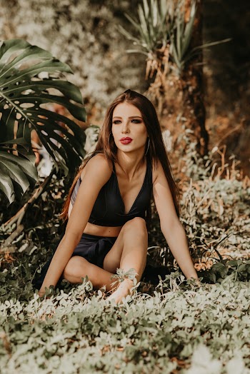 Unknown Celebrity Sitting on Green Grass Field Outdoors