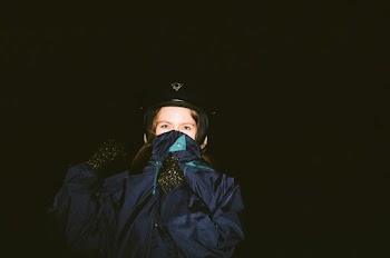 Unknown Person in Blue Zip-up Jacket Wearing Black Motorcycle Helmet