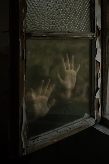 Unknown Person Putting Hands on Glass Window