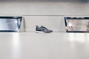 unpaired black and gray Nike running shoe on floor