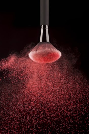 Upside down makeup brush with red powder splash Free Photo